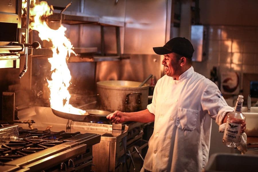 Cocinero salteando con fuego en la cocina de un restaurante
