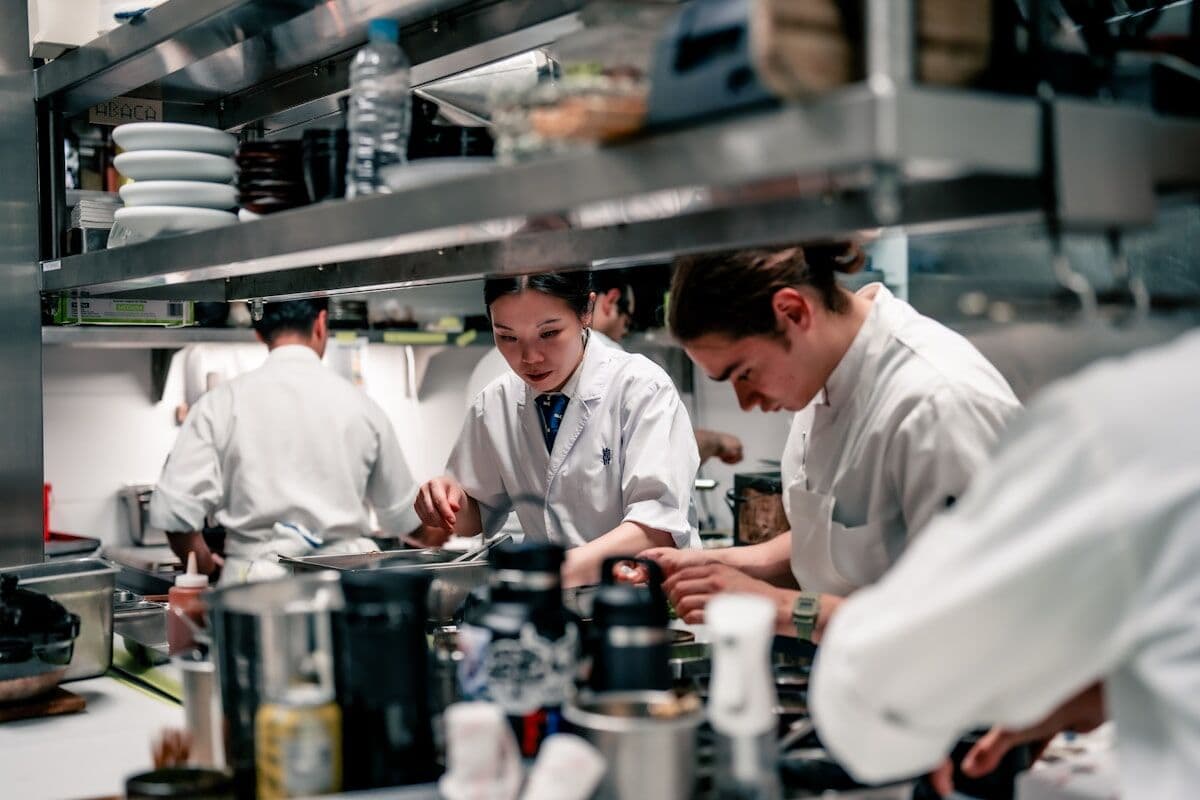 Equipo de cocina trabajando junto en la misma partida durante el servicio