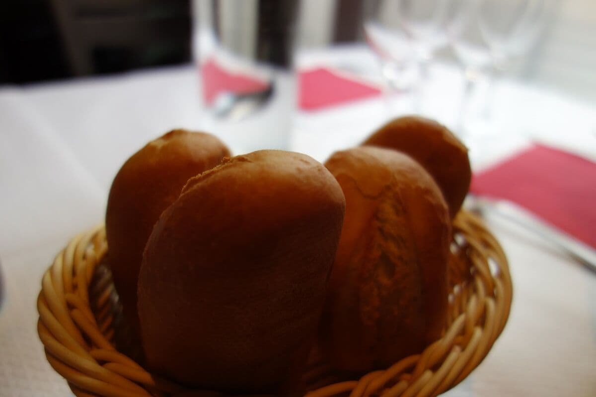Cesta de panecillos sobre la mesa puesta de un restaurante